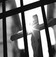 Prison bars in front of a cross